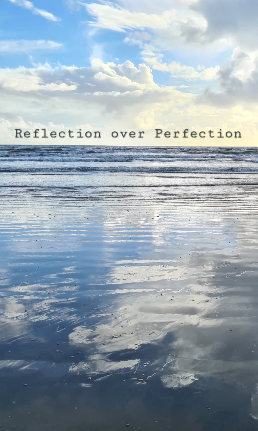 A wide beach beneath a bright blue and cloudy sky, with the clouds reflected in the wet sand. Across the centre of the image are the words “Reflection over Perfection"